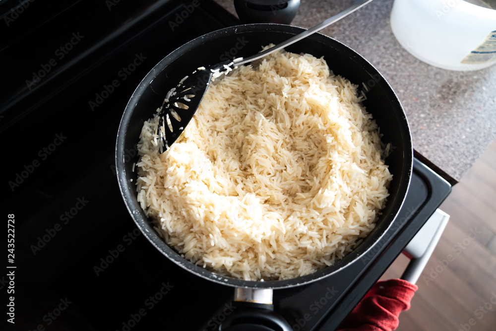 Pot of boiled white rice cooking on kitchen stove Pot of boiled white rice cooking on kitchen stove