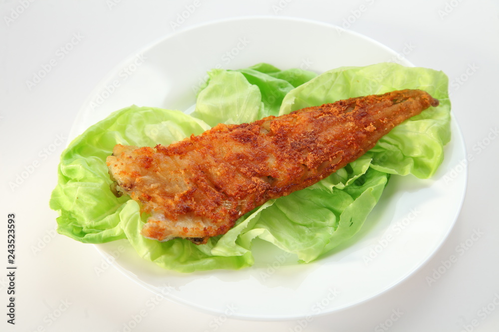 Fried fish with green salad on white plate Fried fish with green salad on white plate