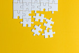 Jigsaw puzzles placed on a yellow background Creative concept with copy space