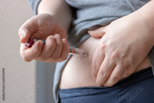 Plus size woman injecting insulin into fat stomach, diabetes, health problems