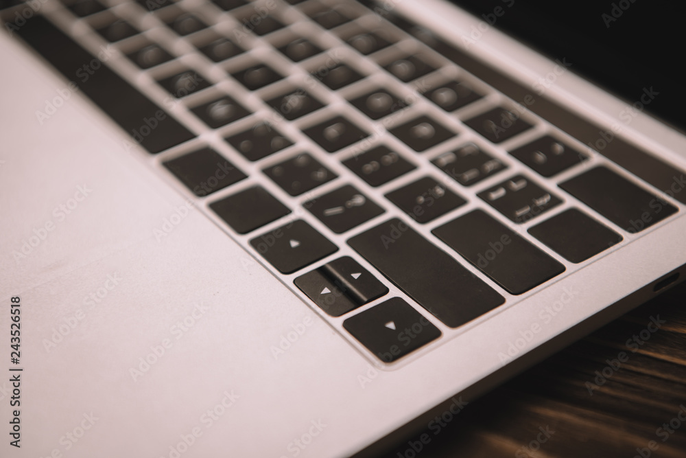 close up of laptop keyboard on wooden table