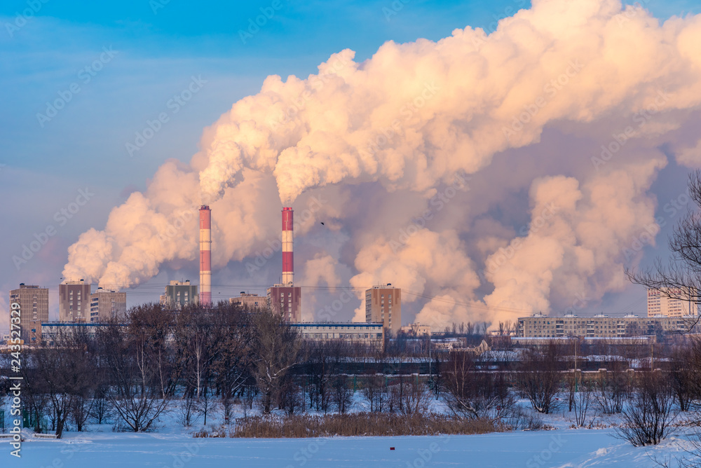 Winter cityscape with pipes of thermal power plant
