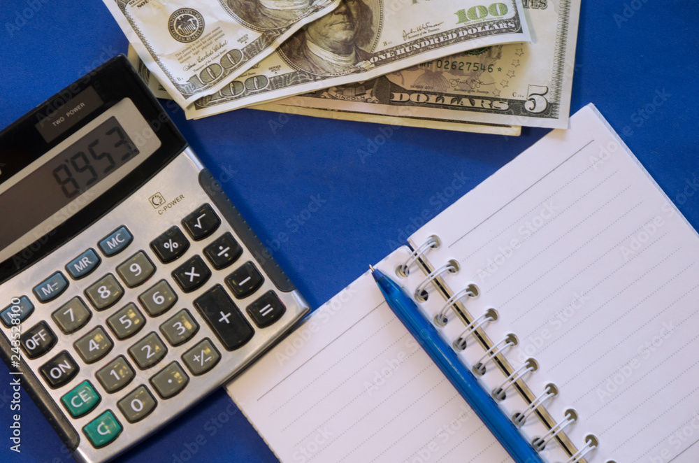 money, notebook, calculator are on a blue background money, notebook, calculator are on a blue background
