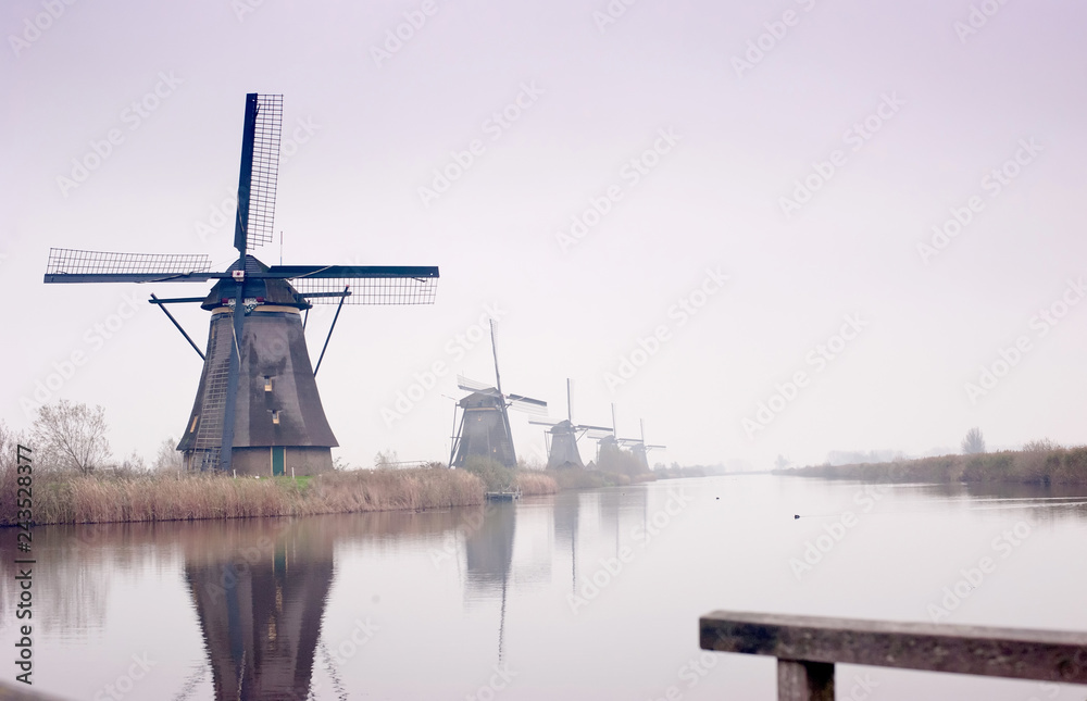 The Famous Netherlands wooden Windmills, UNESCO World Heritage Site, Kinderdijk Windmill village in the soft sunset light of winter.