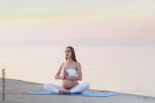 Beautiful pregnant woman doing yoga at the seaside © ElenaBatkova