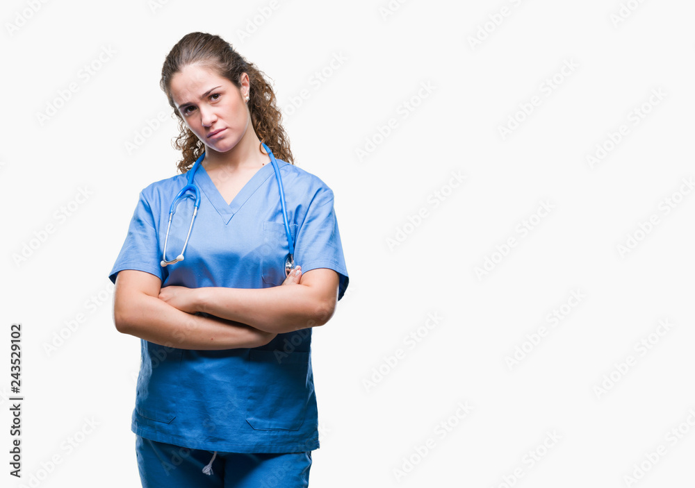 Young brunette doctor girl wearing nurse or surgeon uniform over isolated background skeptic and nervous, disapproving expression on face with crossed arms. Negative person.
