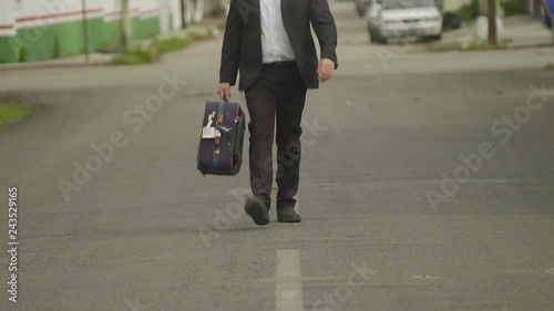 business man or rabbi in suit walk with suitcase on a road in mexican street