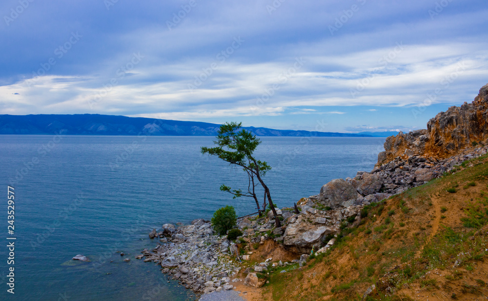 Evening view with Cape Burkhan at the Olkhon Island on Small sea of Baikal lake. Summer vacation in the heart of Siberia. The sacred place of Buddhists and shamans.