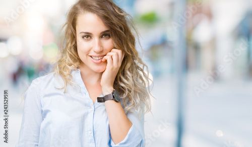 Beautiful young blonde business woman over isolated background looking stressed and nervous with hands on mouth biting nails. Anxiety problem. © Krakenimages.com