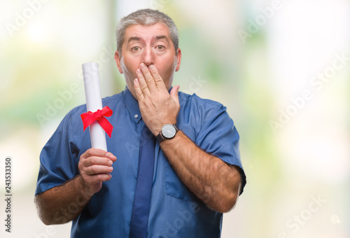 Handsome senior man holding degree over isolated background cover mouth with hand shocked with shame for mistake, expression of fear, scared in silence, secret concept