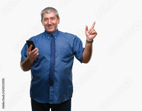 Handsome senior man texting sending message using smartphone over isolated background very happy pointing with hand and finger to the side