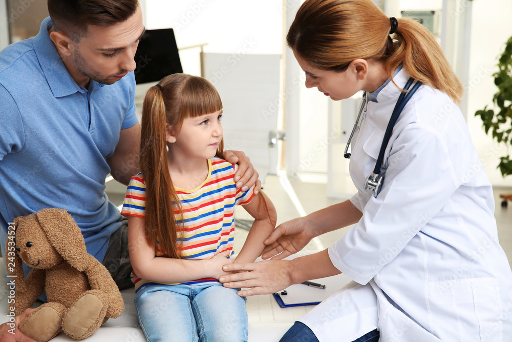 Father and daughter visiting pediatrician. Doctor working with patient in hospital Father and daughter visiting pediatrician. Doctor working with patient in hospital