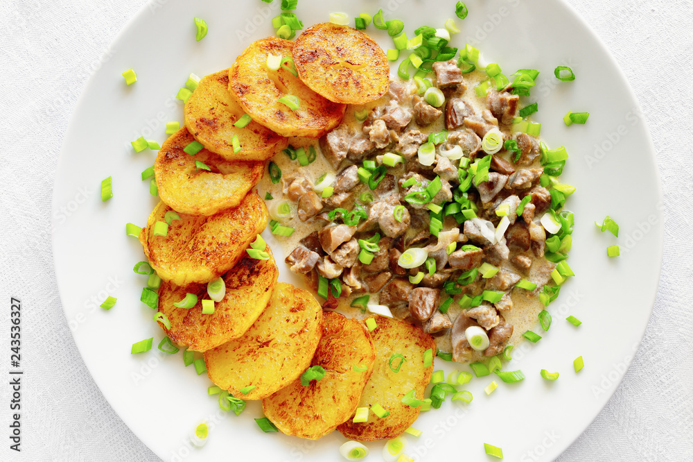 stewed in sour cream chicken offal chops garnished with fried potato and decorated with green onion stewed in sour cream chicken offal chops garnished with fried potato and decorated with green onion