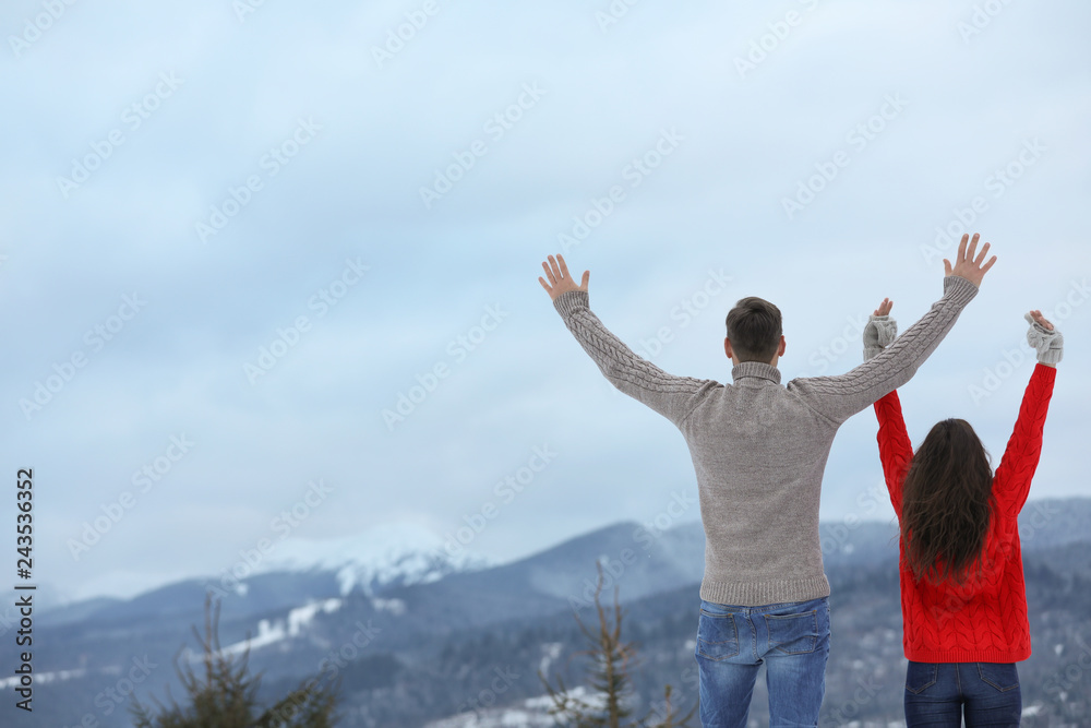 Happy couple enjoying mountain landscape in winter Happy couple enjoying mountain landscape in winter