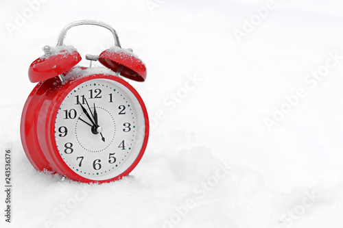 Red alarm clock on white snow outdoors. Space for text
