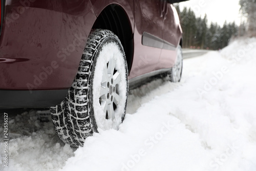 Closeup view of car in snow near road. Space for text
