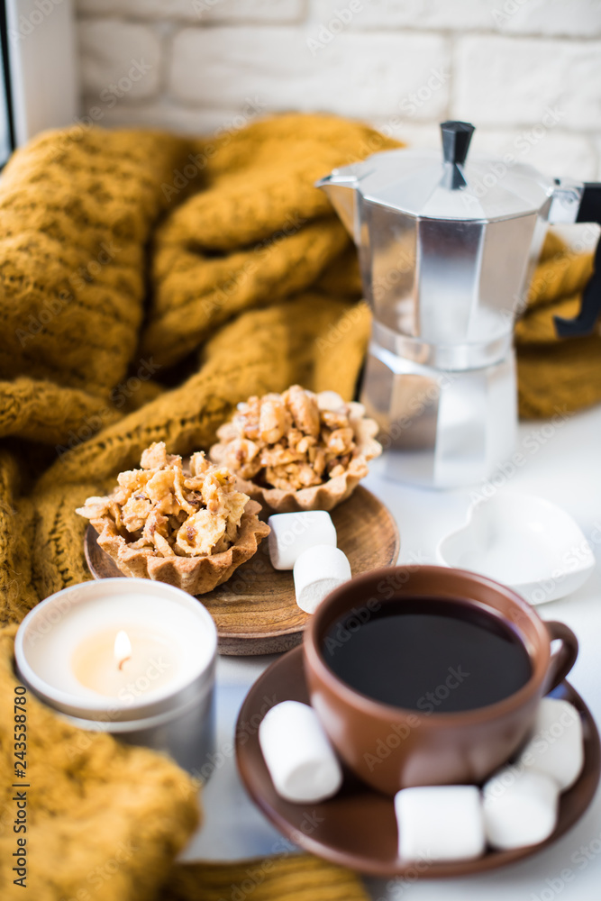 Warm home arrangement on windowsill, coffee and cookies with can