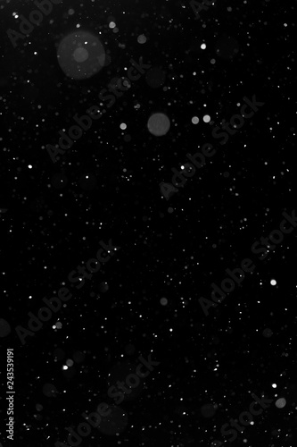 Bokeh white snow on a black night background