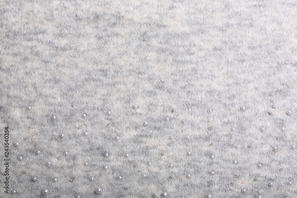 Fototapeta premium Knitted background. Light gray gentle wool background pattern. Background embroidered with beads