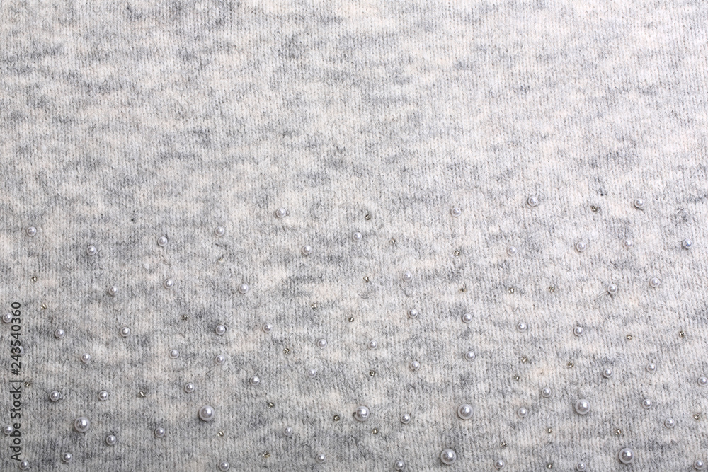 Fototapeta premium Knitted background. Light gray gentle wool background pattern. Background embroidered with beads