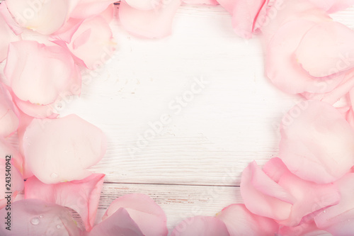 Fototapeta Naklejka Na Ścianę i Meble -  petals of pink roses on a white wooden background