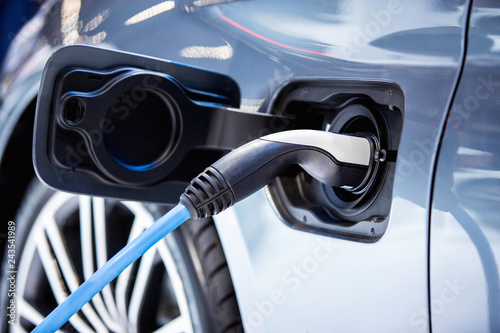 The power supply plugged into an electric car to charging a battery at the charging station