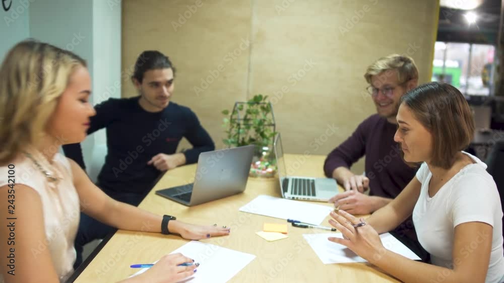Stylish people sitting at the conference table and energetically discussing daily business plans. Stylish people sitting at the conference table and energetically discussing daily business plans.