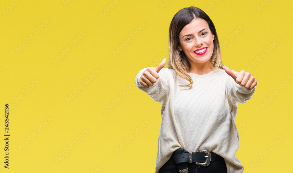 Young beautiful woman casual white sweater over isolated background approving doing positive gesture with hand, thumbs up smiling and happy for success. Looking at the camera, winner gesture. Young beautiful woman casual white sweater over isolated background approving doing positive gesture with hand, thumbs up smiling and happy for success. Looking at the camera, winner gesture.