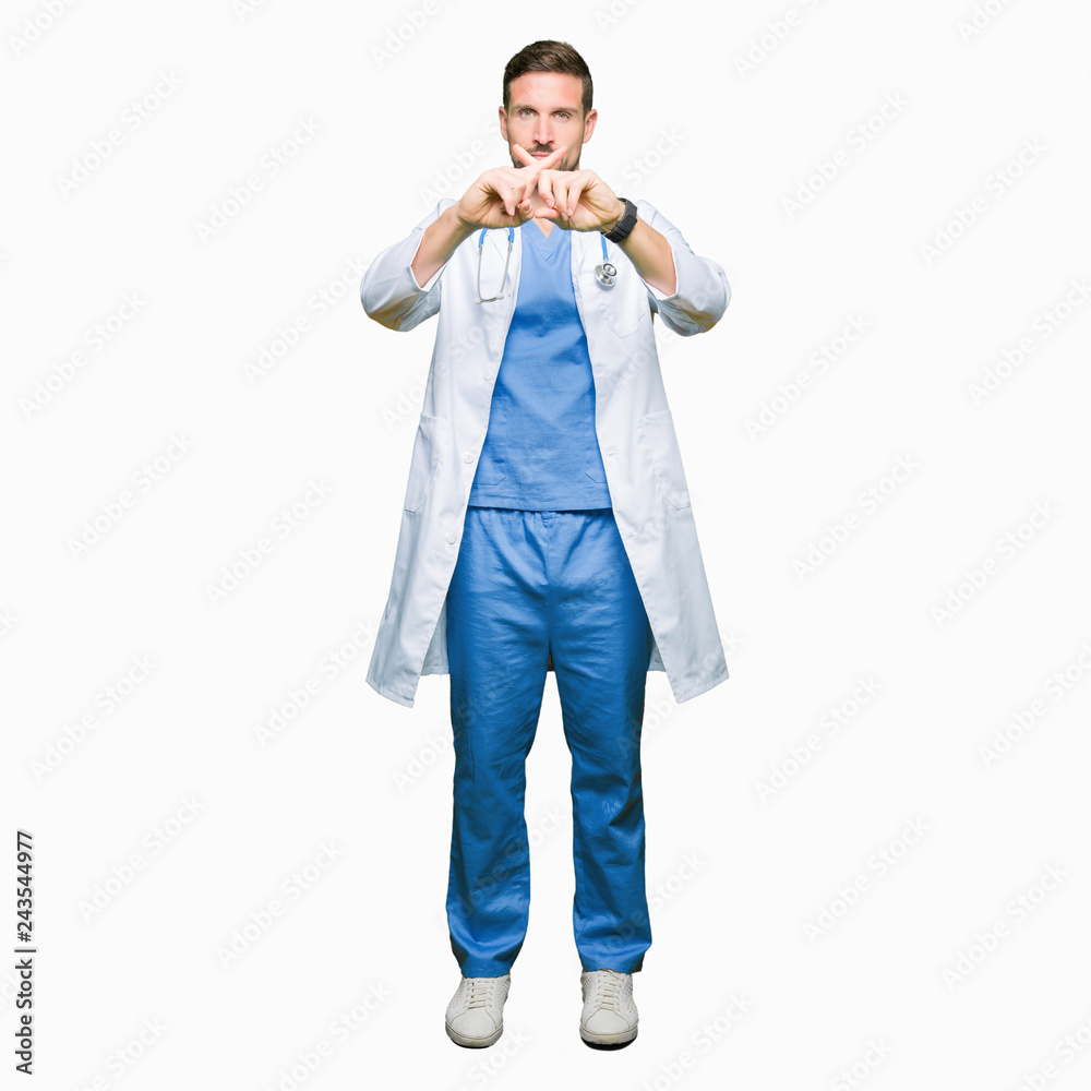 Handsome doctor man wearing medical uniform over isolated background Rejection expression crossing fingers doing negative sign Handsome doctor man wearing medical uniform over isolated background Rejection expression crossing fingers doing negative sign