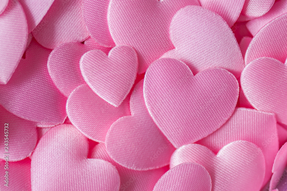 Fototapeta premium Marco of a pink heart for Valentines Day. Valentines Day background with hearts. Satin hearts. Flat lay, soft focus.