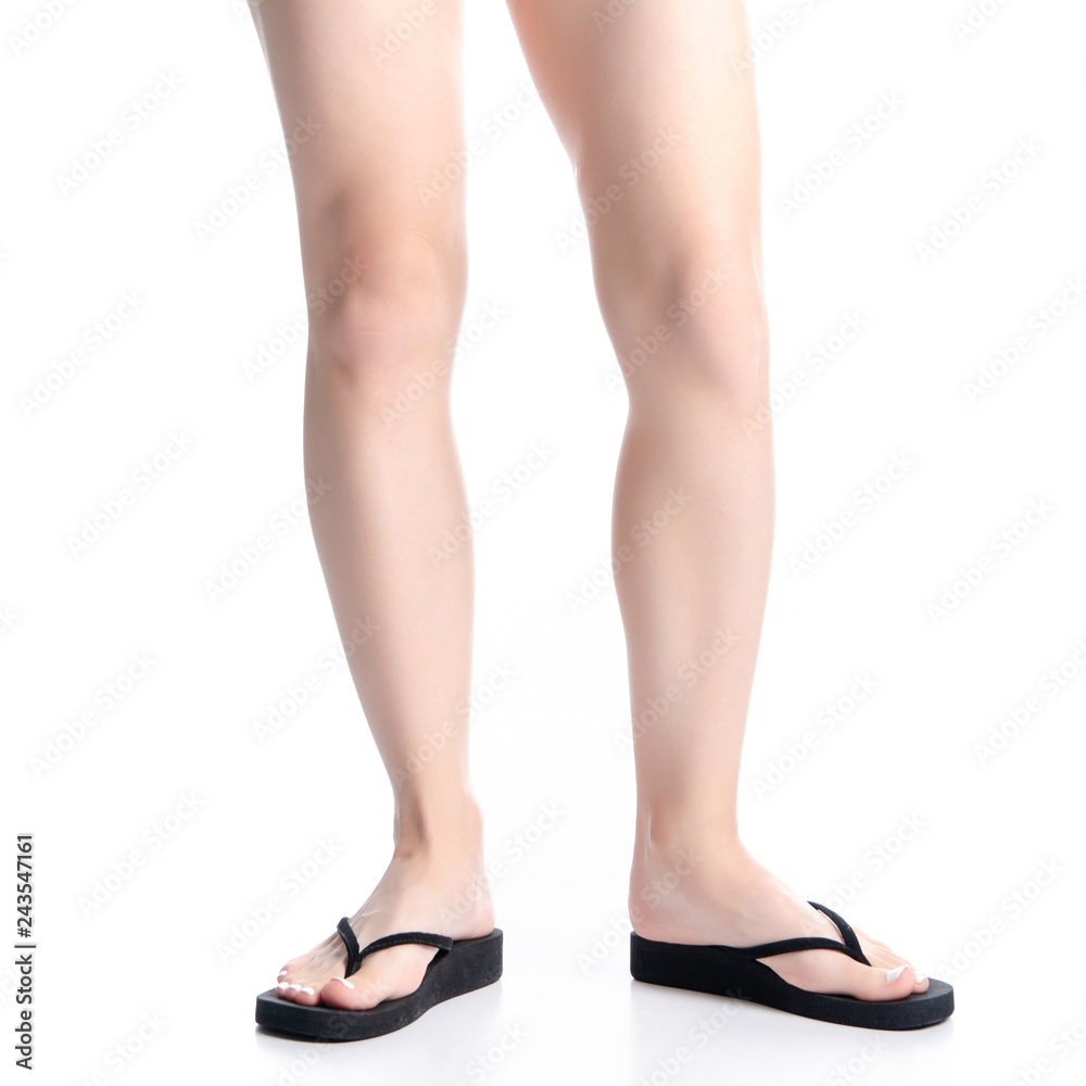 Woman legs in black flip flops on white background isolation Woman legs in black flip flops on white background isolation