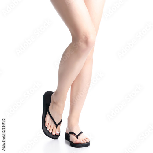 Woman legs in black flip flops on white background isolation