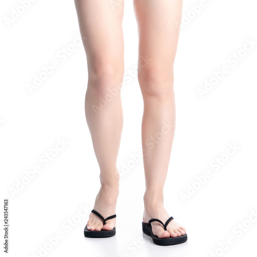 Woman legs in black flip flops on white background isolation