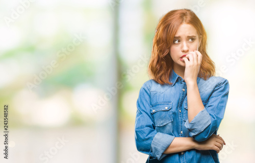 Young beautiful woman over isolated background looking stressed and nervous with hands on mouth biting nails. Anxiety problem.