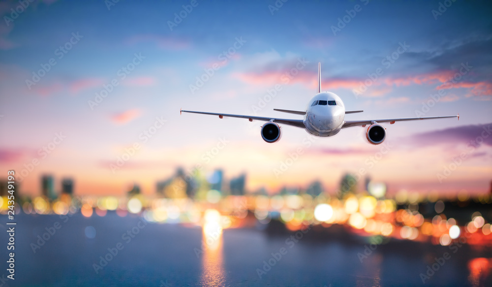 Airplane In Flight At Twilight With Blurred Cityscape 