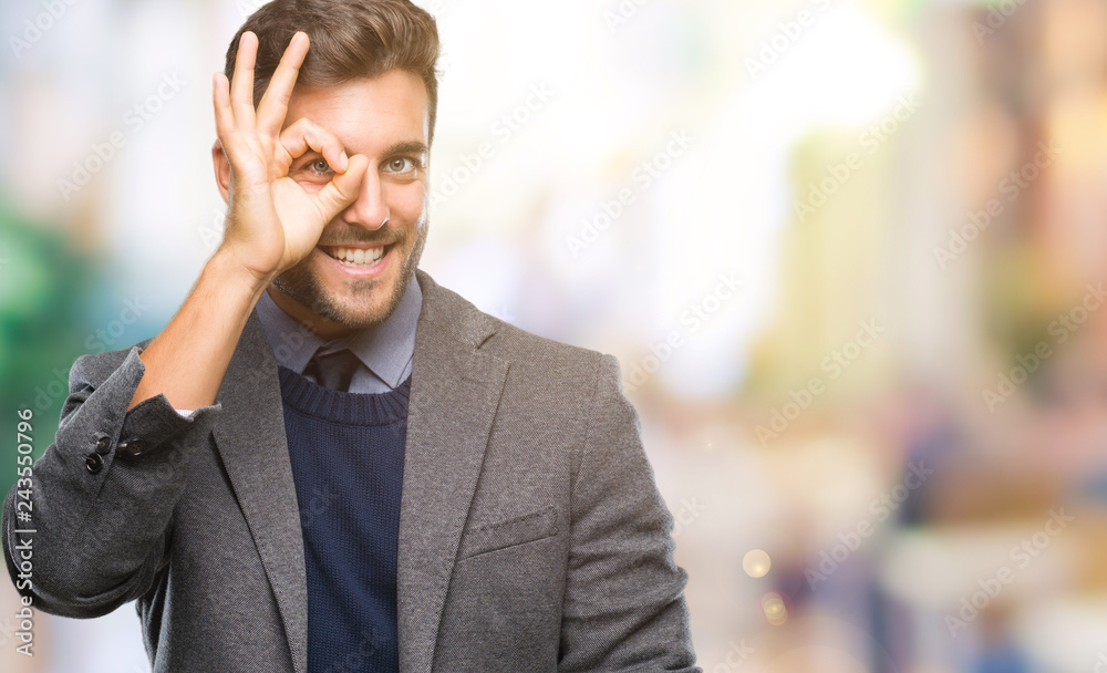Young handsome business man over isolated background doing ok gesture with hand smiling, eye looking through fingers with happy face. Young handsome business man over isolated background doing ok gesture with hand smiling, eye looking through fingers with happy face.