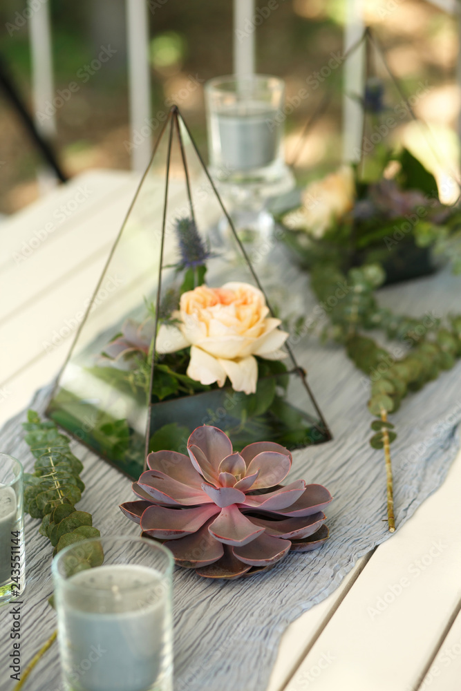 Florarium with fresh succulent and rose flowers festive table decoration. Event fresh flowers decoration. Florist workflow. Wedding banquet design
