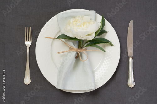 Romantic dinner. Elegance table setting with white peony on linen tablecloth. Top view.