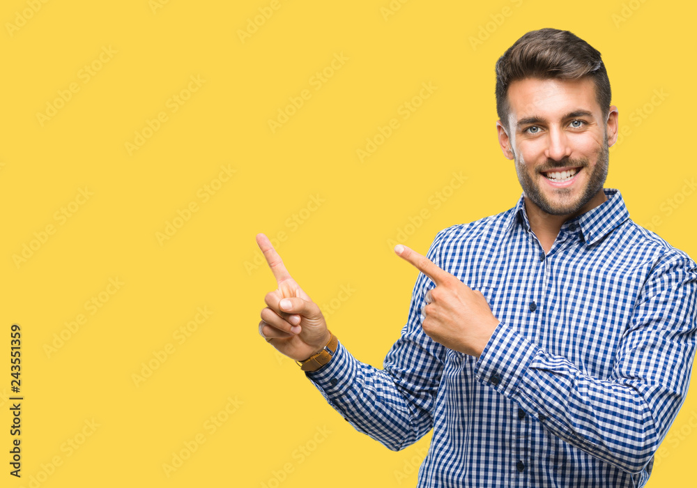 Young handsome man over isolated background smiling and looking at the camera pointing with two hands and fingers to the side. Young handsome man over isolated background smiling and looking at the camera pointing with two hands and fingers to the side.