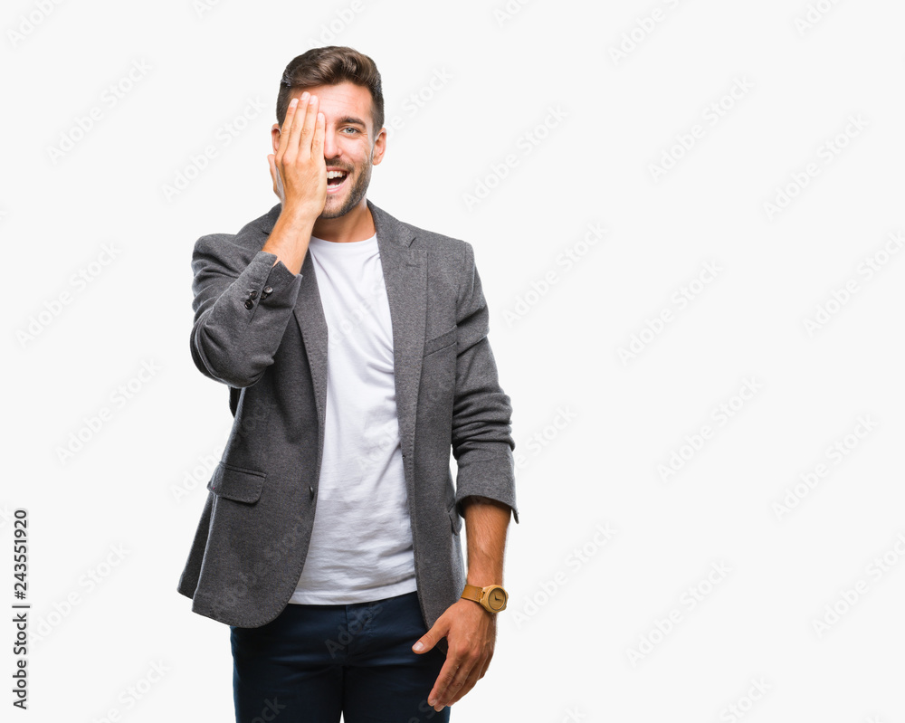 Young handsome business man over isolated background covering one eye with hand with confident smile on face and surprise emotion. Young handsome business man over isolated background covering one eye with hand with confident smile on face and surprise emotion.