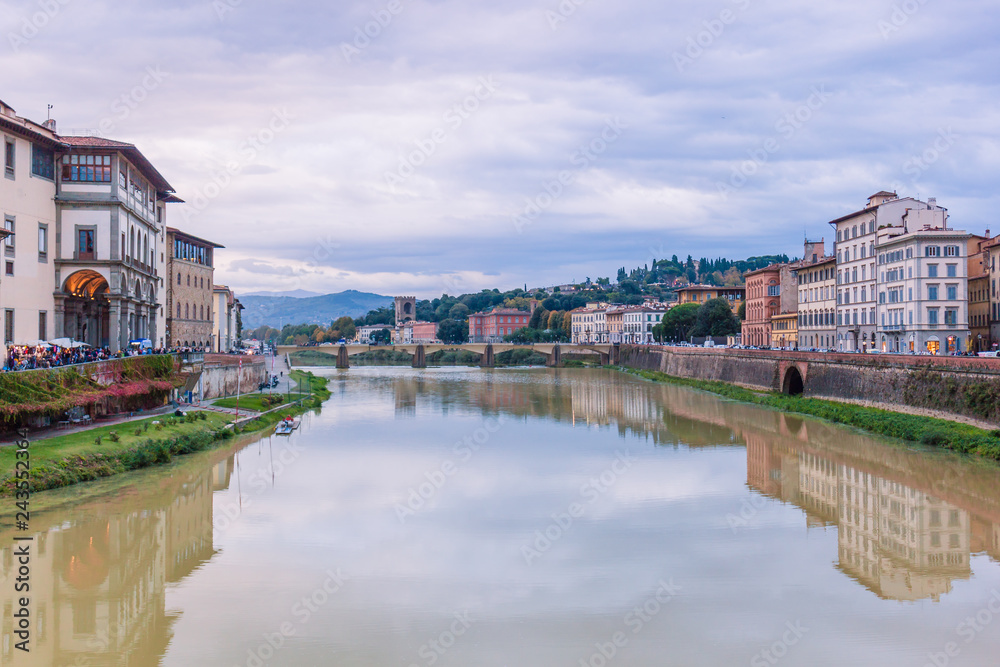 Colorful old buildings on the bank of Arno river in Florence, Italy with reflection in water. Medieval architecture