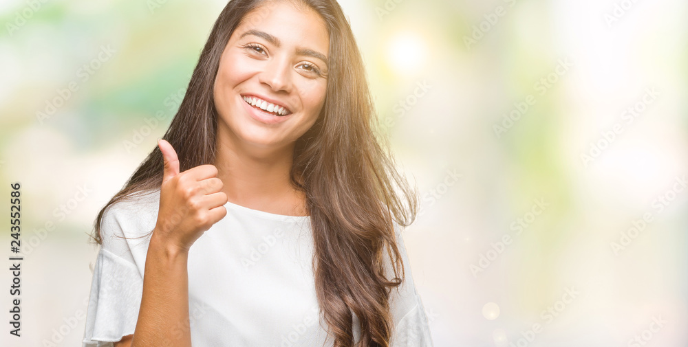 Young beautiful arab woman over isolated background doing happy thumbs up gesture with hand. Approving expression looking at the camera with showing success. Young beautiful arab woman over isolated background doing happy thumbs up gesture with hand. Approving expression looking at the camera with showing success.