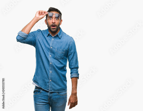 Photos Adult hispanic man wearing sunglasses over isolated background afraid and shocked with surprise expression, fear and excited face