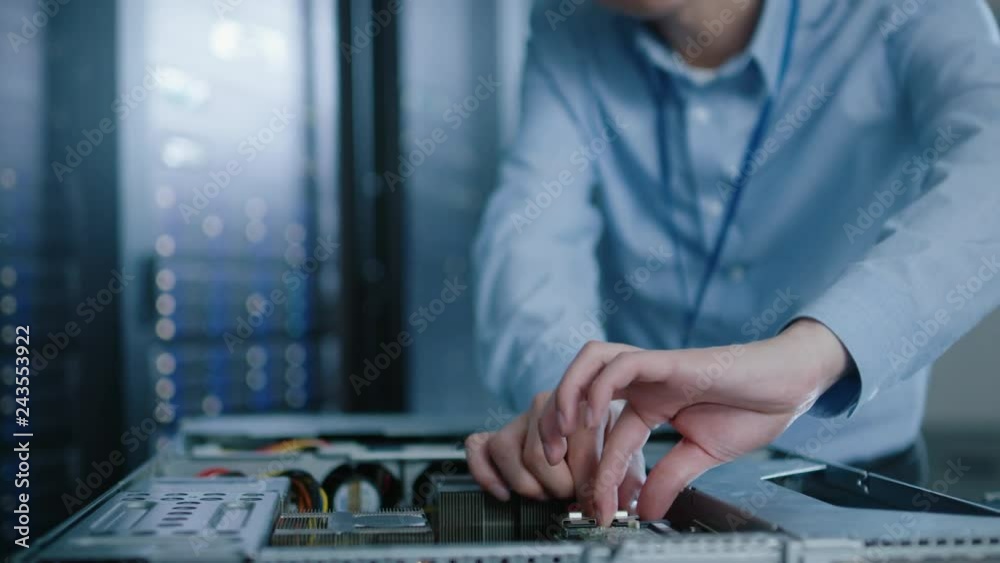 In the Modern Data Center: IT Engineer Wearing Protective Headphones Installs New Hardware for Server Rack. IT Specialist Doing Maintenance, Running Diagnostics and Updating Hardware. In the Modern Data Center: IT Engineer Wearing Protective Headphones Installs New Hardware for Server Rack. IT Specialist Doing Maintenance, Running Diagnostics and Updating Hardware.