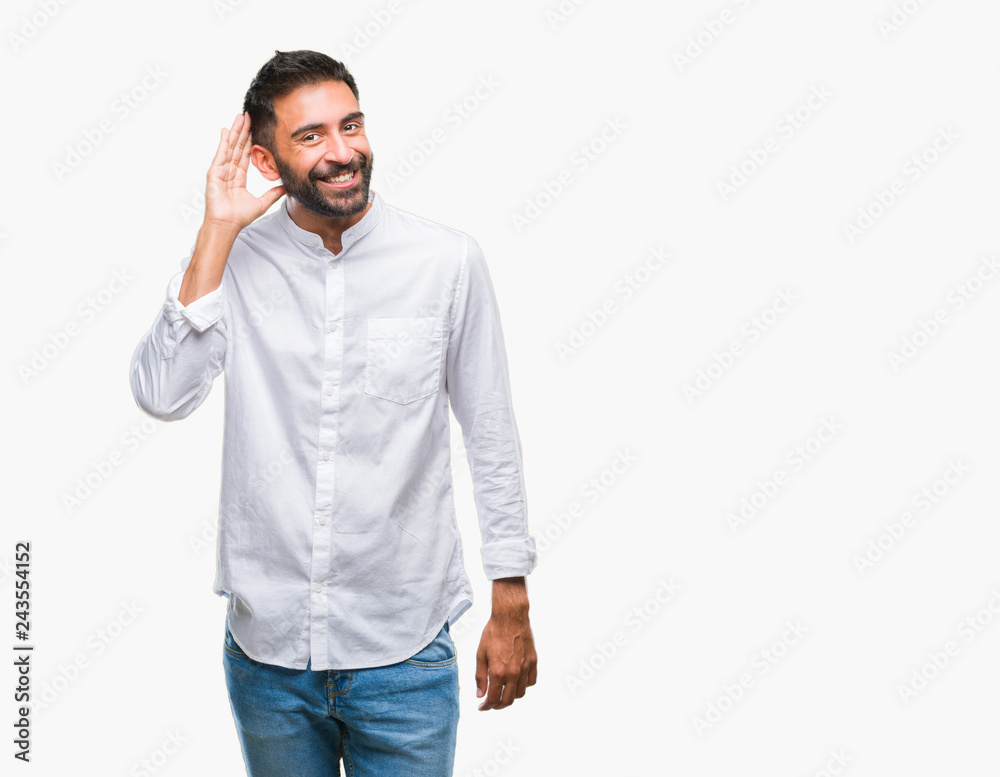 Adult hispanic man over isolated background smiling with hand over ear listening an hearing to rumor or gossip. Deafness concept. Adult hispanic man over isolated background smiling with hand over ear listening an hearing to rumor or gossip. Deafness concept.