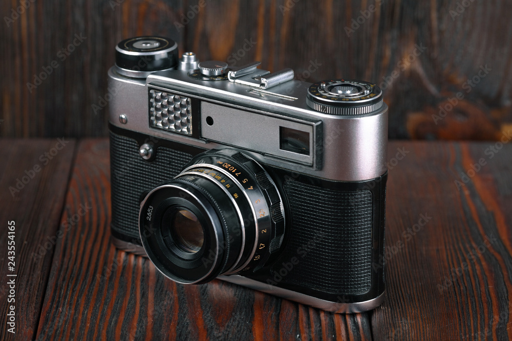 The old rangefinder camera on a brown wooden background.