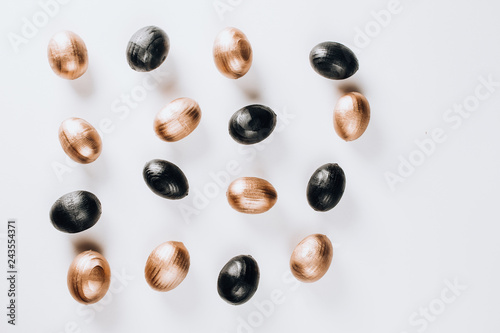 Black and gold eggs over white background.
