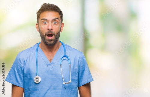 Adult hispanic doctor or surgeon man over isolated background afraid and shocked with surprise expression, fear and excited face. © Krakenimages.com