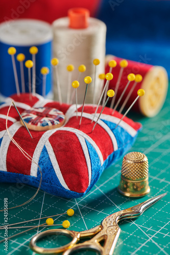 Pincushion like Union Jack on green craft mat, sewing accessories