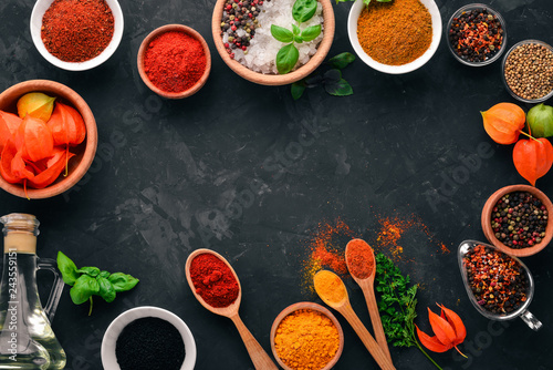 Fototapeta Naklejka Na Ścianę i Meble -  A set of spices and herbs on a stone table. Indian traditional spices. Top view. Free copy space.